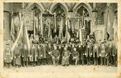 A festively dressed group in front of the portal entrance to St. Barbara of Röhlinghausen - Photo card, 1912 at the earliest [the year of the church's consecration]
