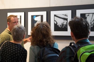 Uczestnicy i uczestniczki wyjazdu studyjnego  - Uczestnicy i uczestniczki wyjazdu studyjnego przed historycznymi fotografiami, które posłużyły Gerhardowi Richterowi za wzór do jego cyklu "Birkenau", Berlin 2019. 