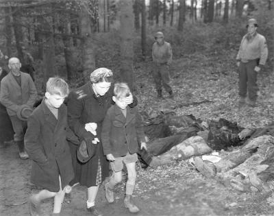 German mother shields eyes of son as she walks with other civilians past row of exhumed dead Russians outside town of Suttrop - German mother shields eyes of son as she walks with other civilians past row of exhumed dead Russians outside town of Suttrop 