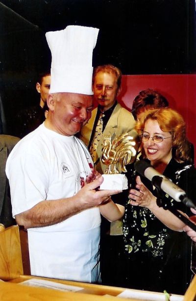 Bäcker Sarzyński (links) überreicht Maria Końska-Chmielecki einen goldenen Hahn - Als Anerkennung für das von ihr geschriebene Stück zur Legende der Kleinstadt Kazimierz Dolny, 1999